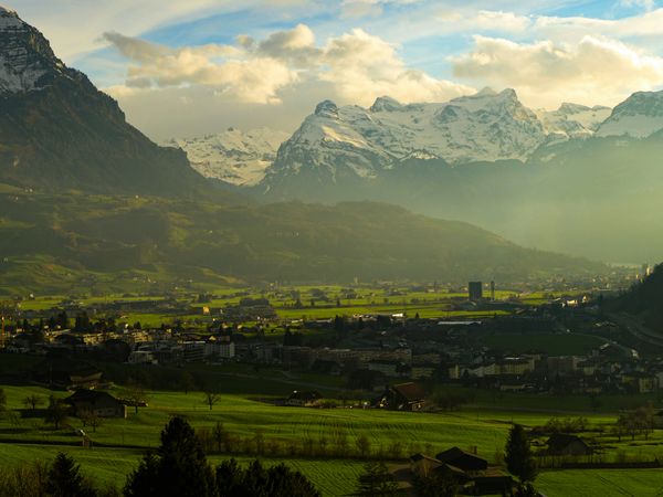 Foto einer kleinen Stadt umgeben von Hügeln und Bergen